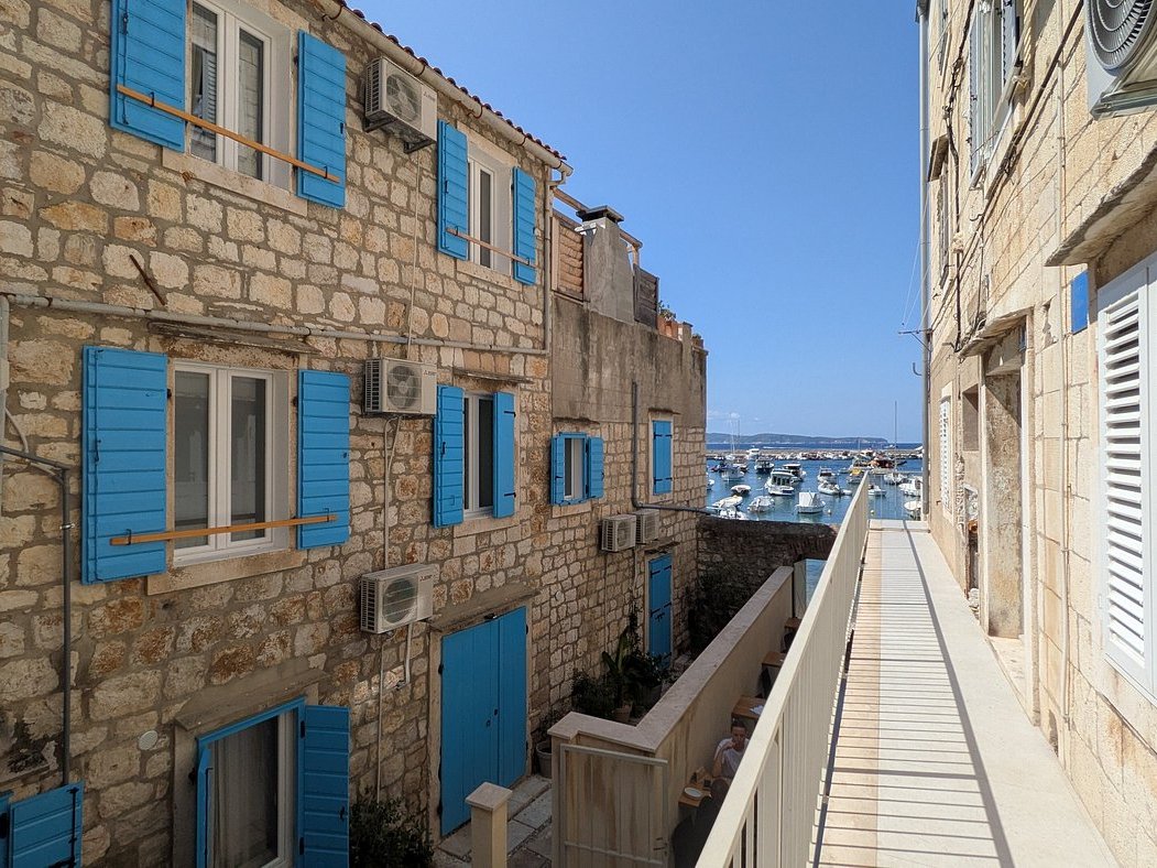 Harbour view from a Hvar Town alley lined with blue shutters