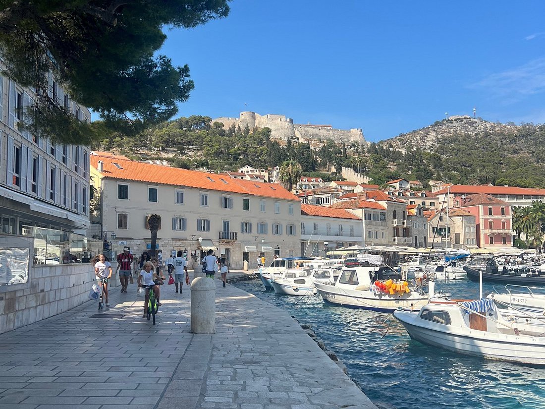 Hvar Riva promenade and harbour with Fortica fortress on the hill