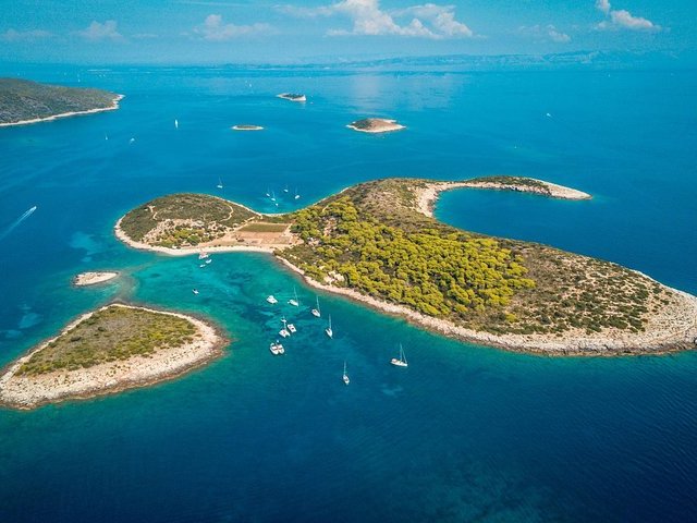 Aerial view of a turquoise lagoon and anchored boats among Dalmatian islets