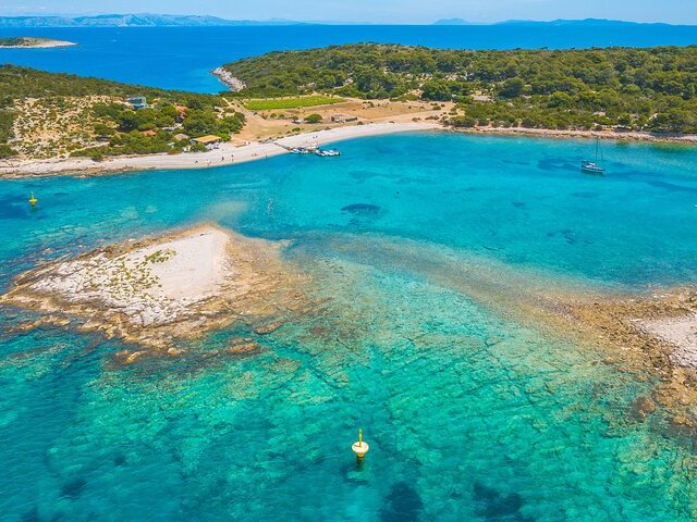 Aerial view of a pebble beach and turquoise bay on the Vis coast