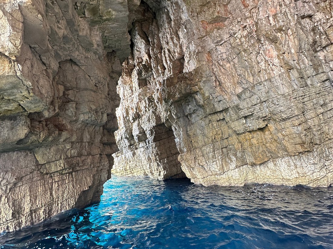 View from a boat through a turquoise passage between towering cliffs