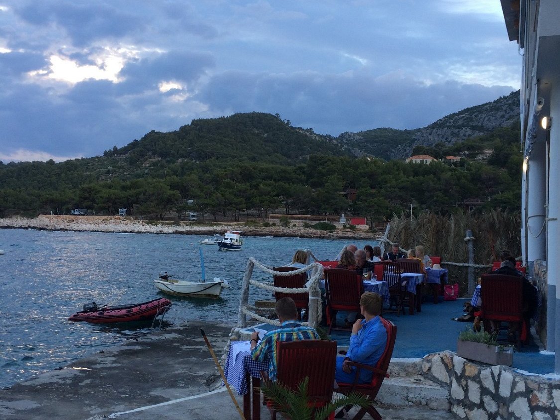 Checkered terrace tables overlooking the bay and boats in Milna