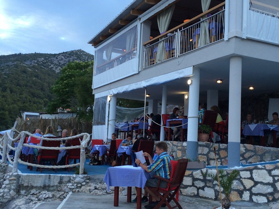 Coastal restaurant terraces on the rocky shoreline in Milna on Hvar