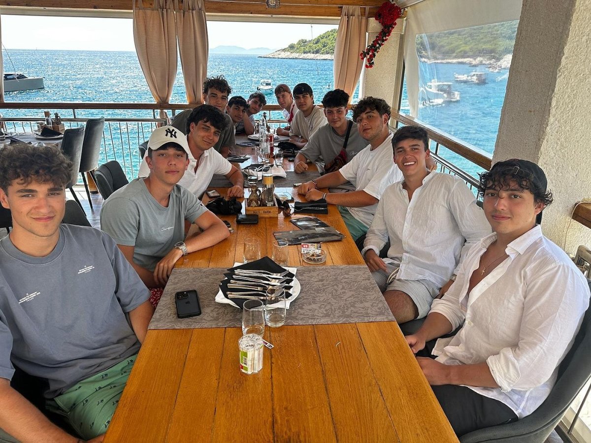 Group lunch at a long terrace table with panoramic sea view