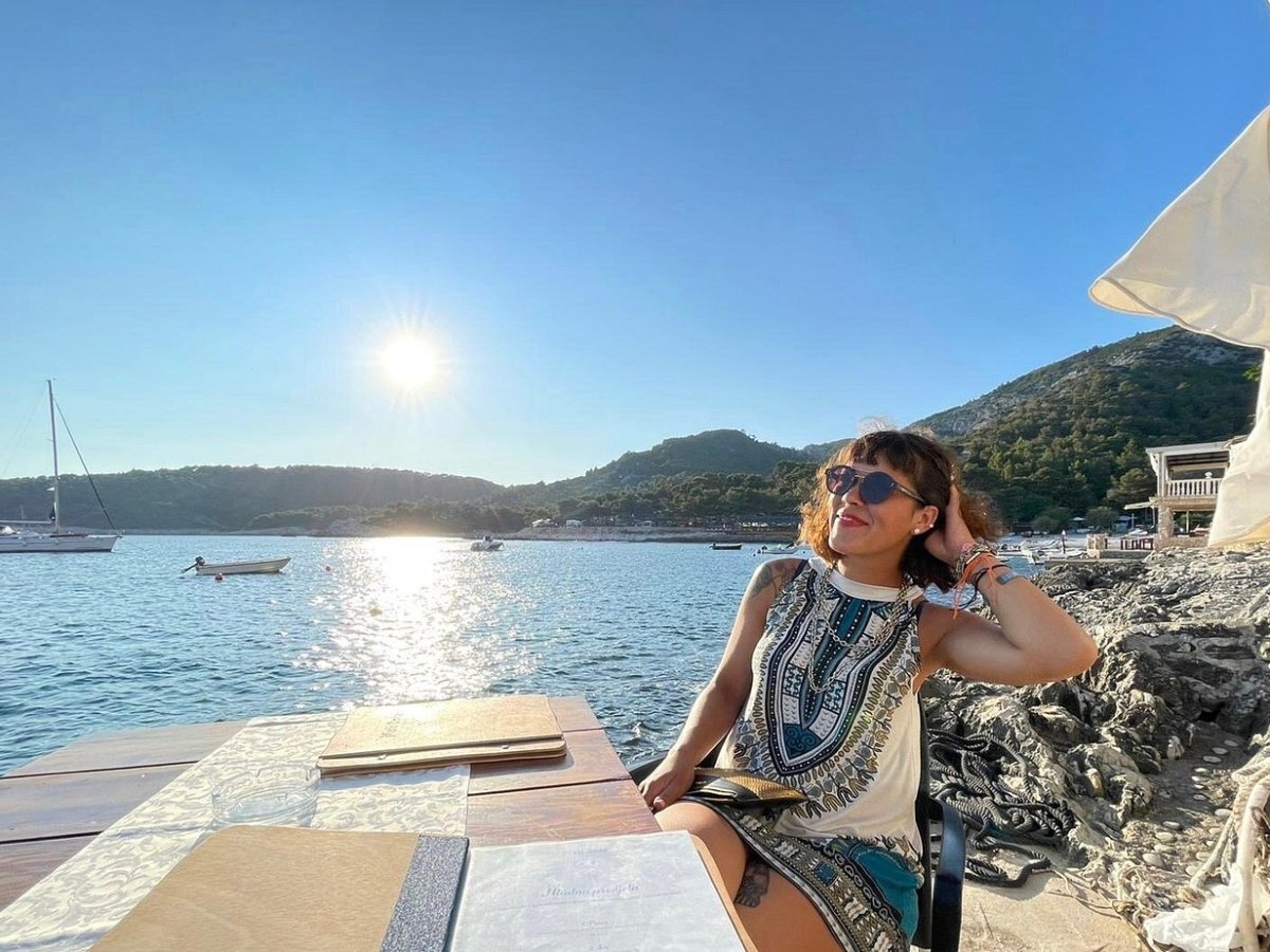 Waterfront terrace overlooking the sunny bay and boats in Milna